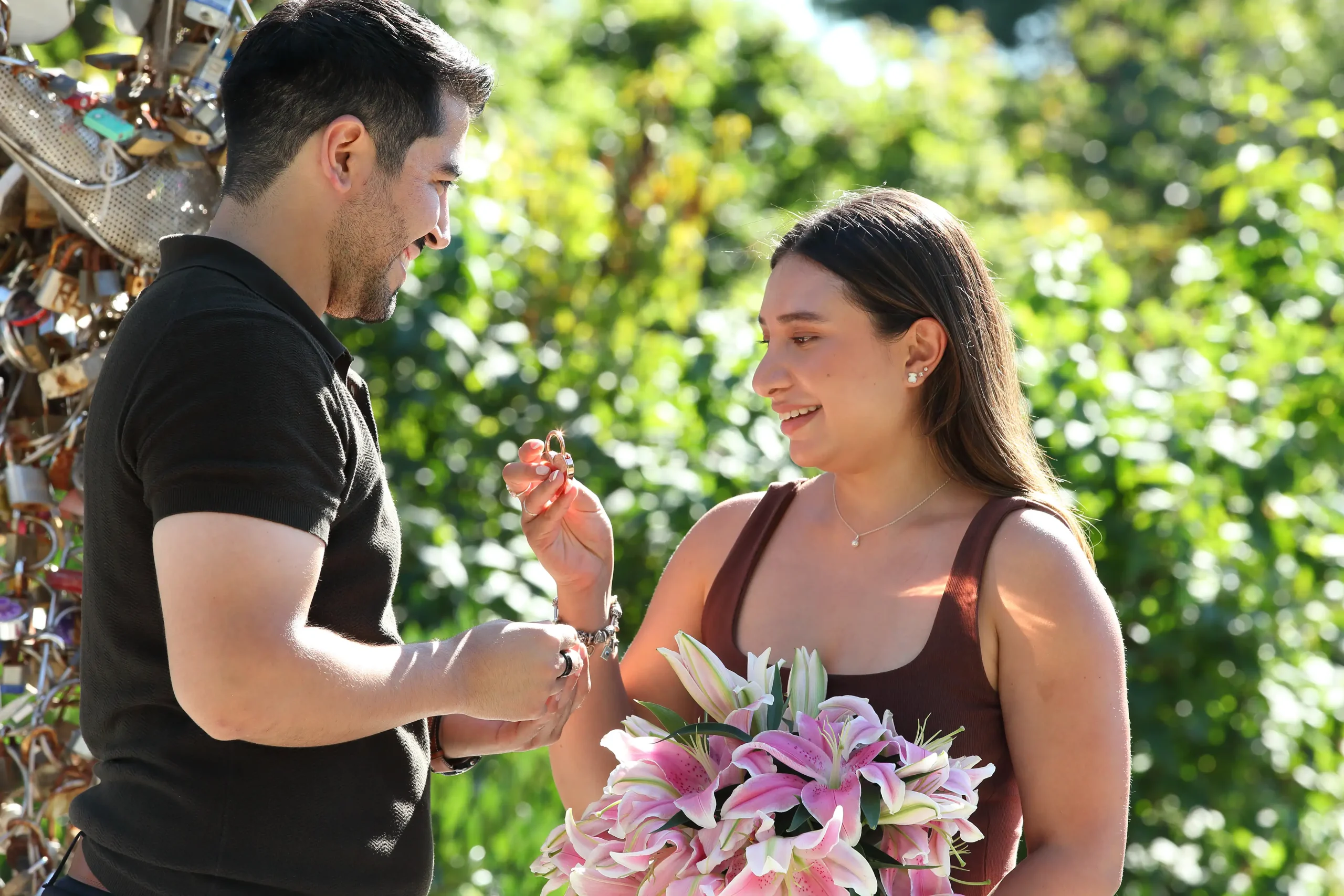 An engagement couple at the park securing a love lock.
