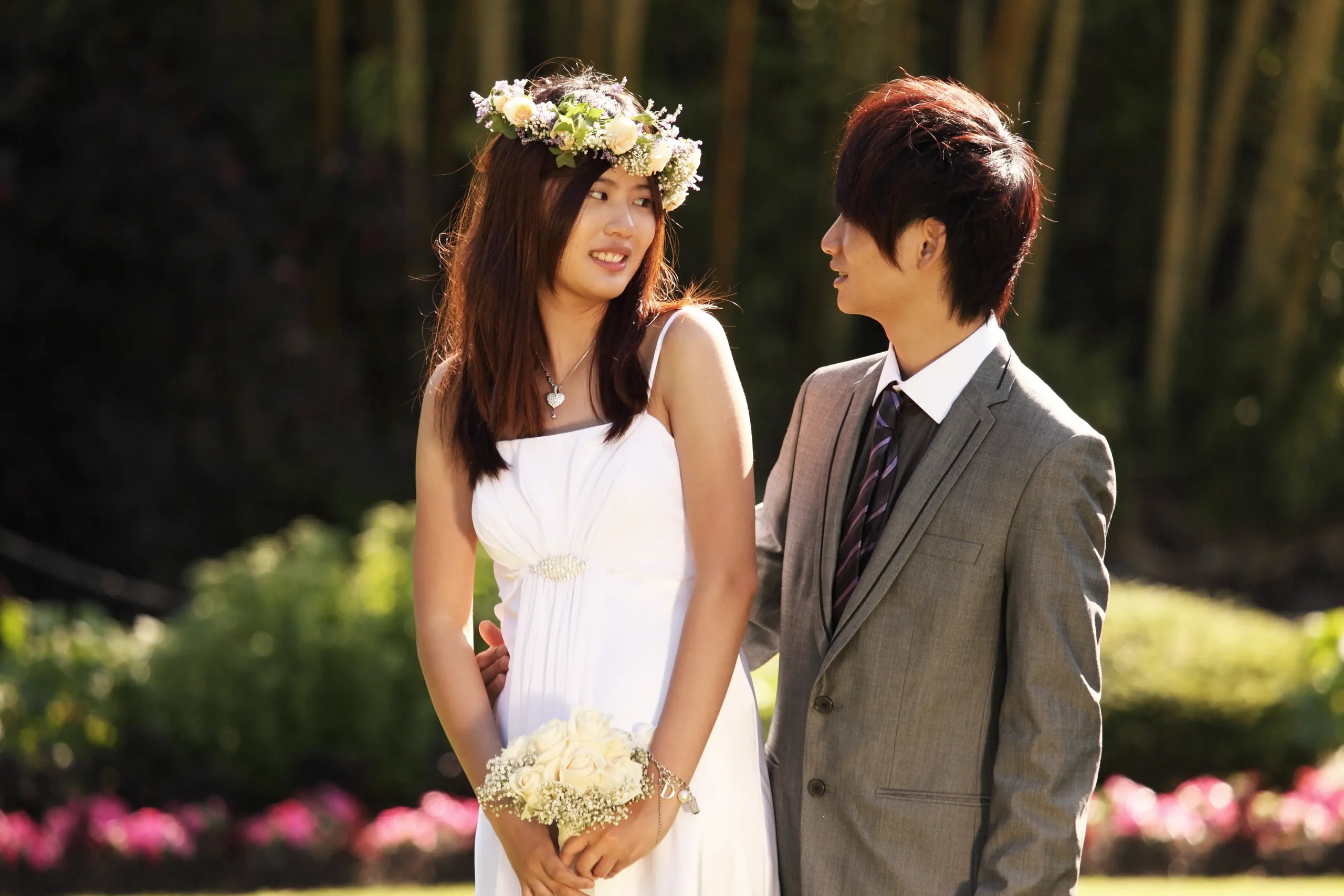 A wedding couple at the park during the sunny Summer season.